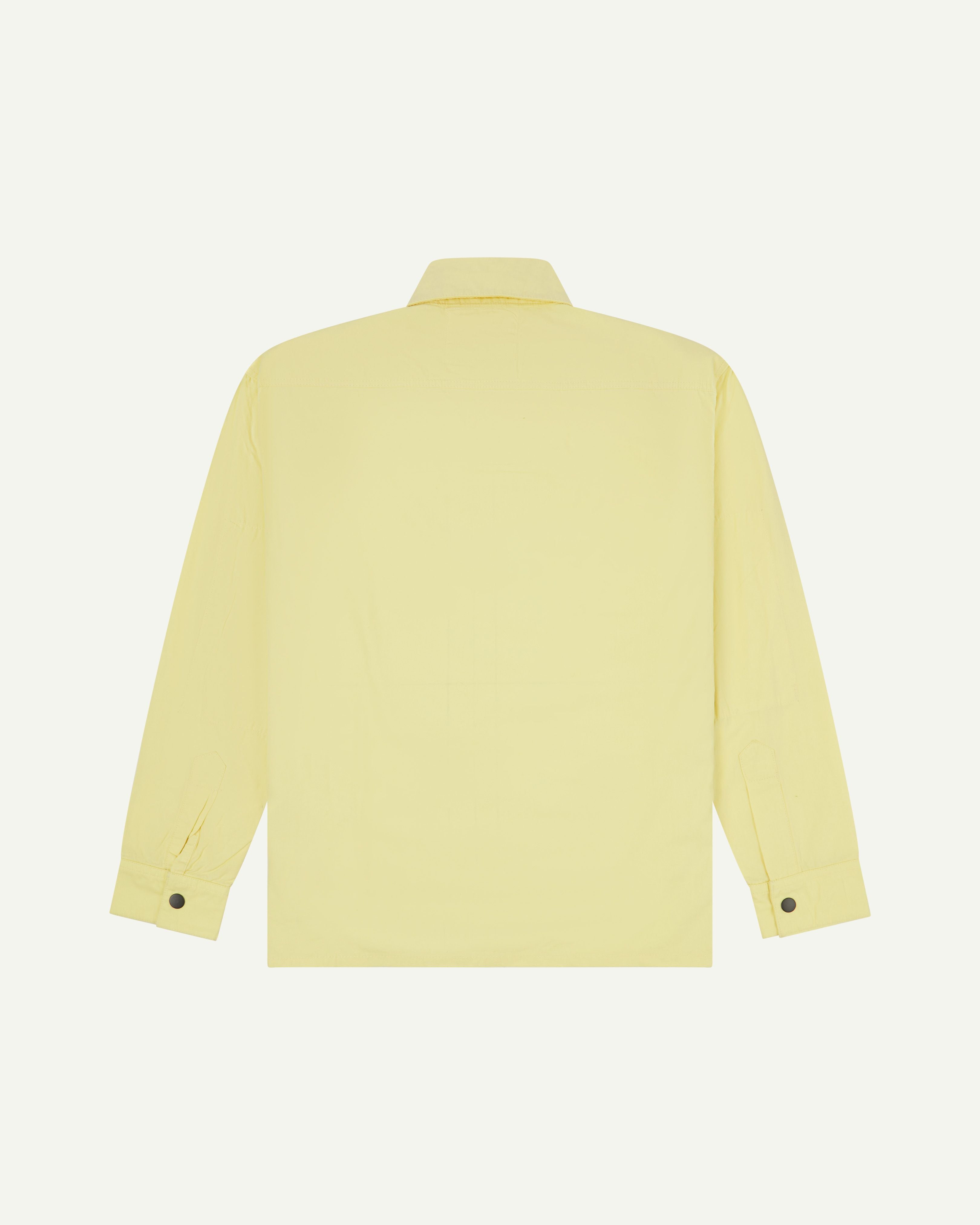 back-view of pale yellow buttoned lightweight long sleeve overshirt from Uskees. Showing black press studs on cuffs