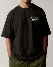  model shot of uskees faded black slouchy style graphic Tee for men showing the 'Diner' design in cream