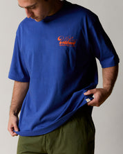 Front model shot of uskees ultra blue relaxed fit graphic Tee for men showing the 'Diner' design in orange