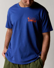 front shot of model wearing  the uskees men's graphic Tee in ultra blue showing the 'diner' logo in orange