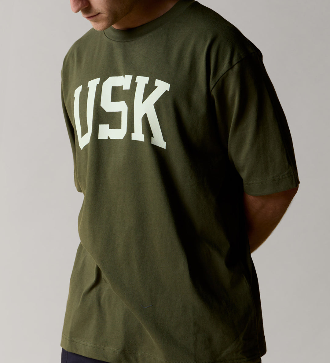 front model shot of coriander green uskees relaxed fit signature t-shirt showing the cream USK logo