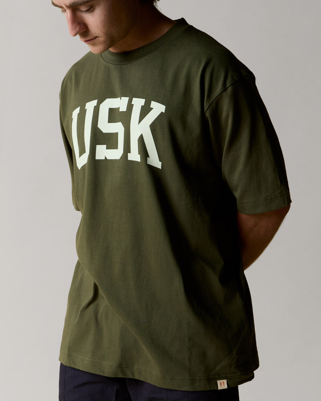 front model shot of coriander green uskees relaxed fit signature t-shirt showing the cream USK logo