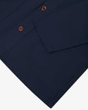 Closer view of mid section of midnight blue, buttoned organic cotton overshirt from Uskees. Focus on cuff, pockets and corozo buttons.