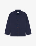 Front flat shot of midnight blue, buttoned organic cotton overshirt. Clear view of chest and hip pockets, corozo buttons and Uskees branding label.