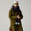 Male model wearing an Uskees corduroy suit in woodland green and a signature baseball cap