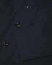 Close up view of dark blue organic cotton drill commuter blazer showing front buttons and cuff detail