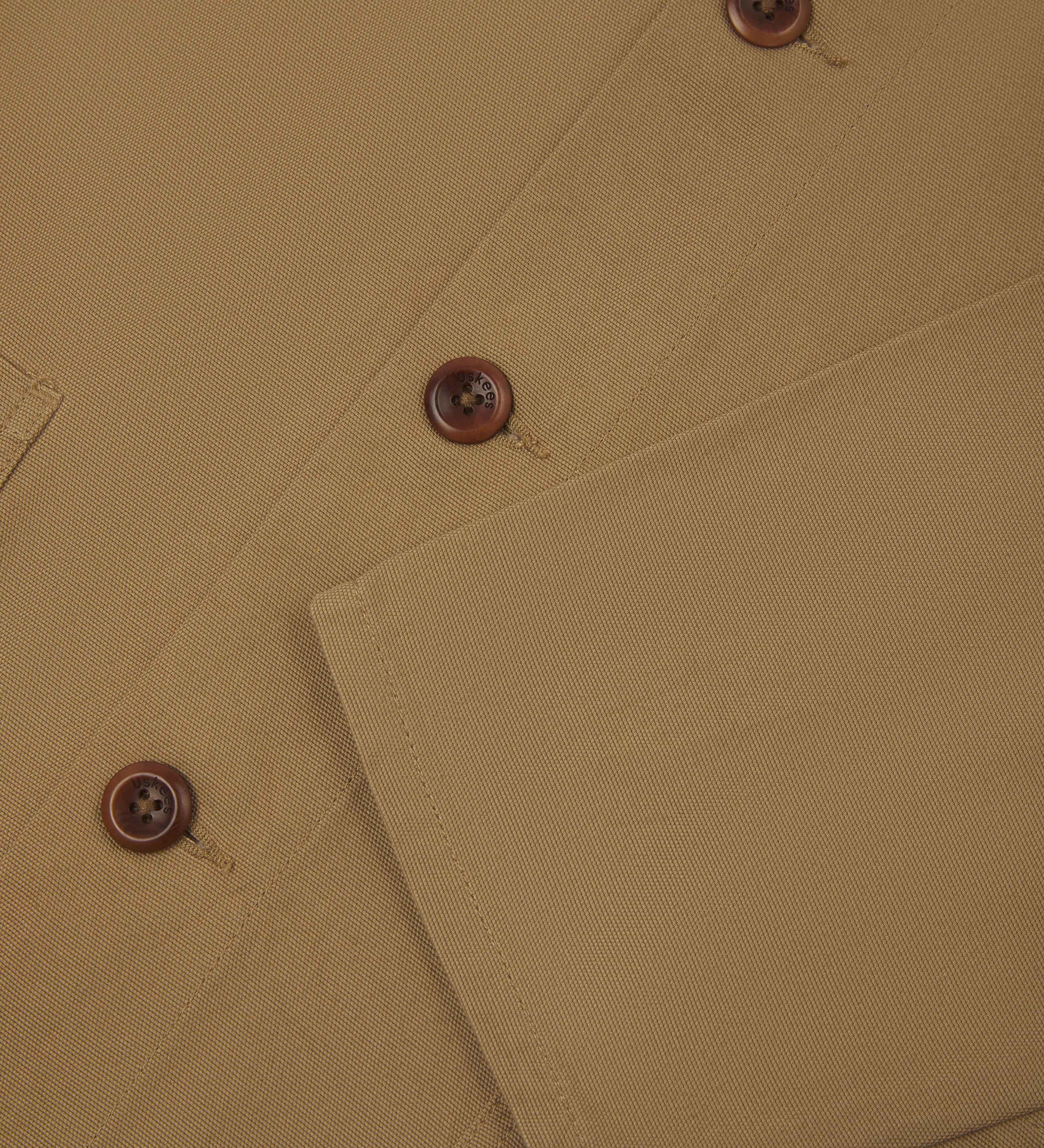 Close up front detail view of khaki buttoned overshirt from Uskees. Clear view of corozo buttons.