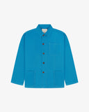 Front flat shot of bright blue, buttoned organic cotton overshirt. Clear view of chest and hip pockets, corozo buttons and Uskees branding label.