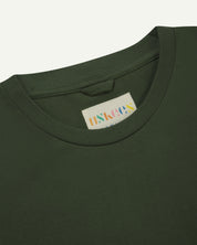 Close-up front shot of Uskees #7010 long sleeve t-shirt in coriander green showing Uskees branded label on inside neck.