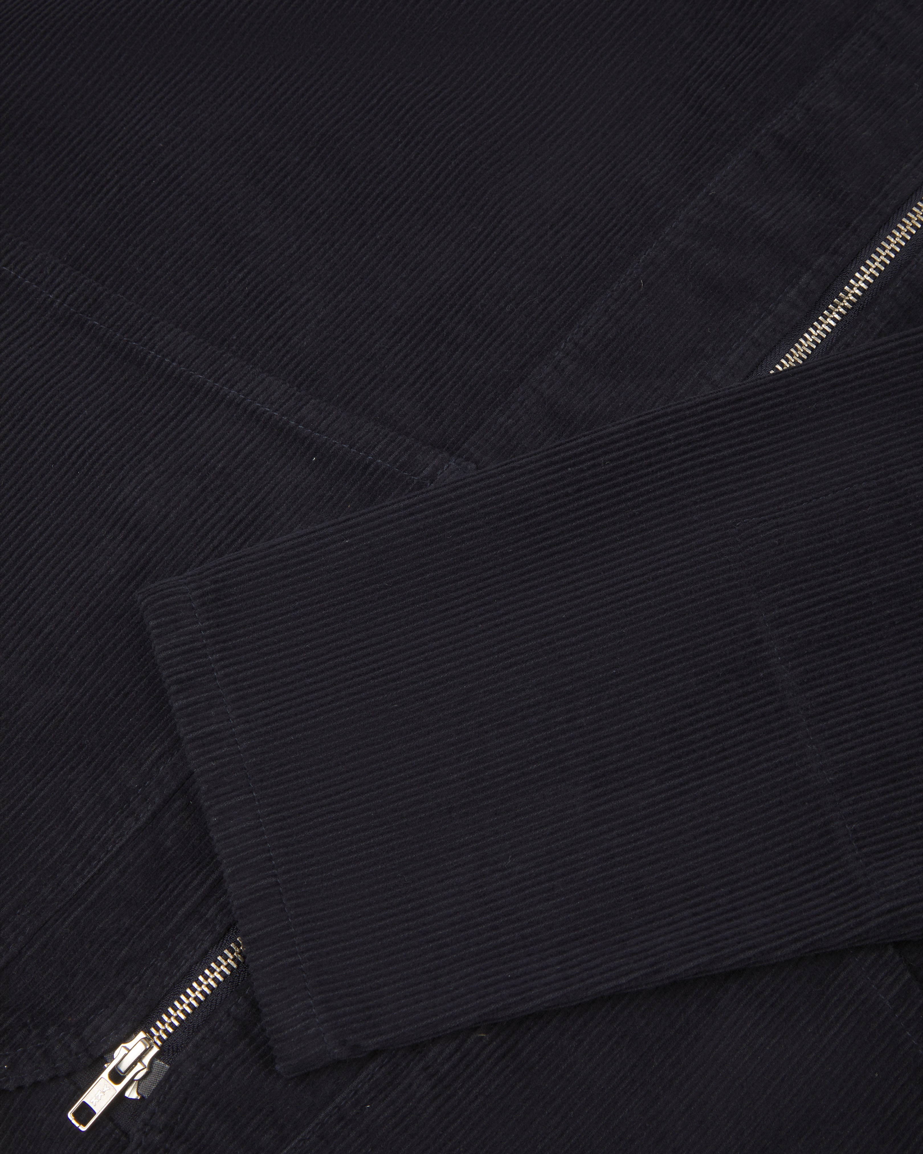 front flat shot of uskees collarless zip front jacket in dark blue corduroy showing the cuff/sleeve in close-up