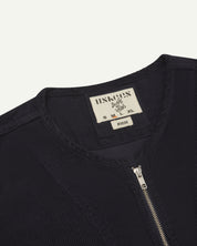 front flat close-up shot of uskees collarless zip front jacket in dark blue corduroy showing the brand and size label at the neck