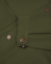 Close-up view of uskees cotton canvas chore jacket in coriander green  showing the adjuster buttons on the cuffs