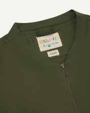 close-up flat shot of uskees green gilet-type zip front waistcoat showing neck, zip and inner brand label at neck