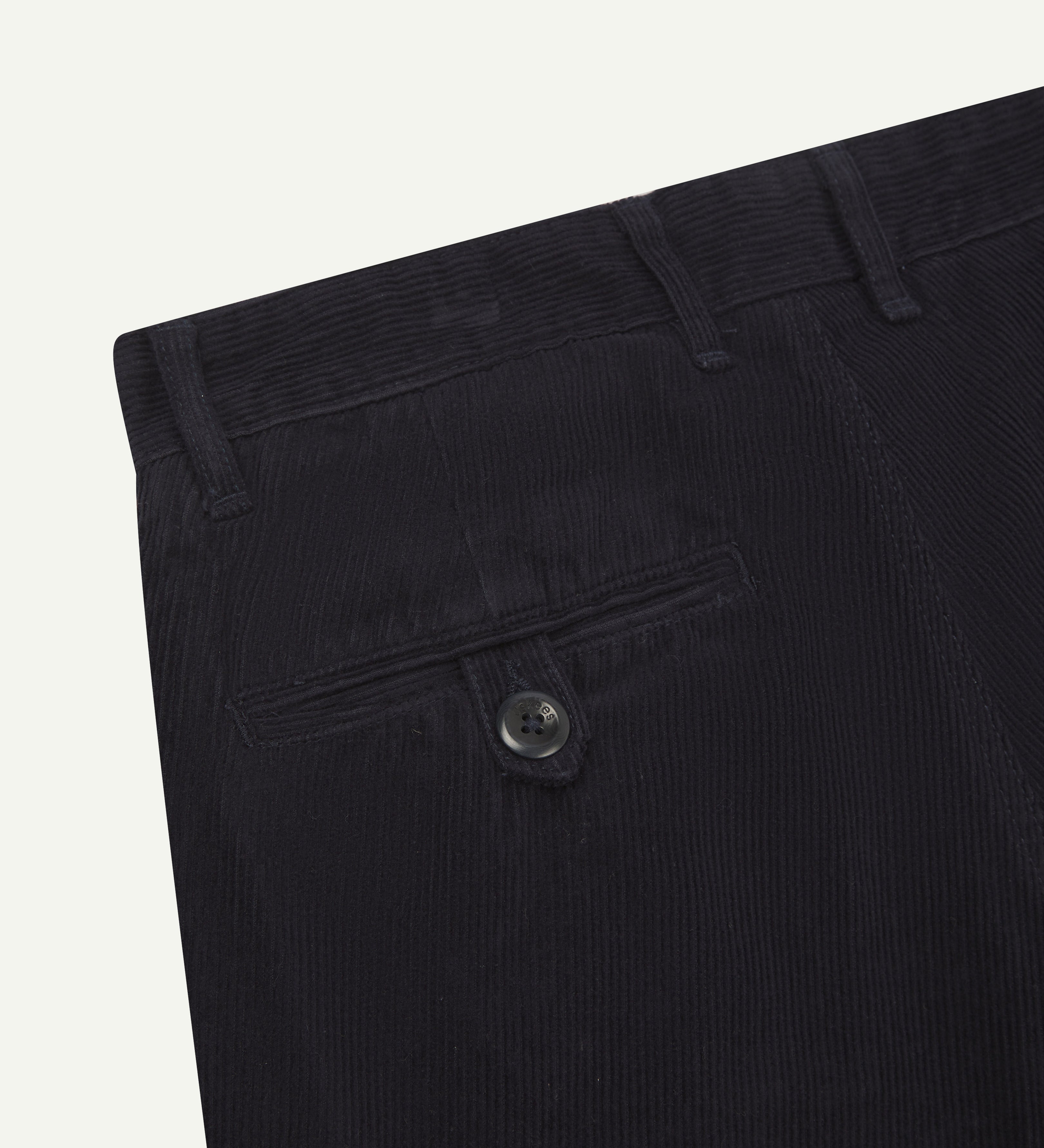 Back flat shot of #5018 Uskees men's organic corduroy boat trousers in navy blue showing belt loops and buttoned back pocket.