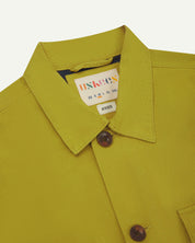Front close up shot of uskees pear green workshirt for men showing brand label at neck and corozo button fastening
