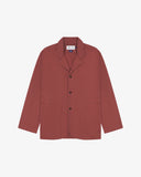 Chestnut-brown buttoned organic cotton-drill blazer from Uskees with clear view of three patch pockets and Uskees branding label.