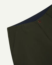 Close-up view of Uskees vine green work pants with focus on natural corozo button, belt loops and triple stitching.