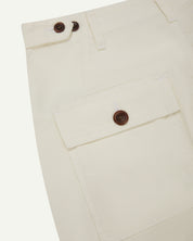 Back view of #5014 Uskees men's organic cotton cream cargo trousers showing contrast brown corozo buttons on pockets and to adjust at waist.