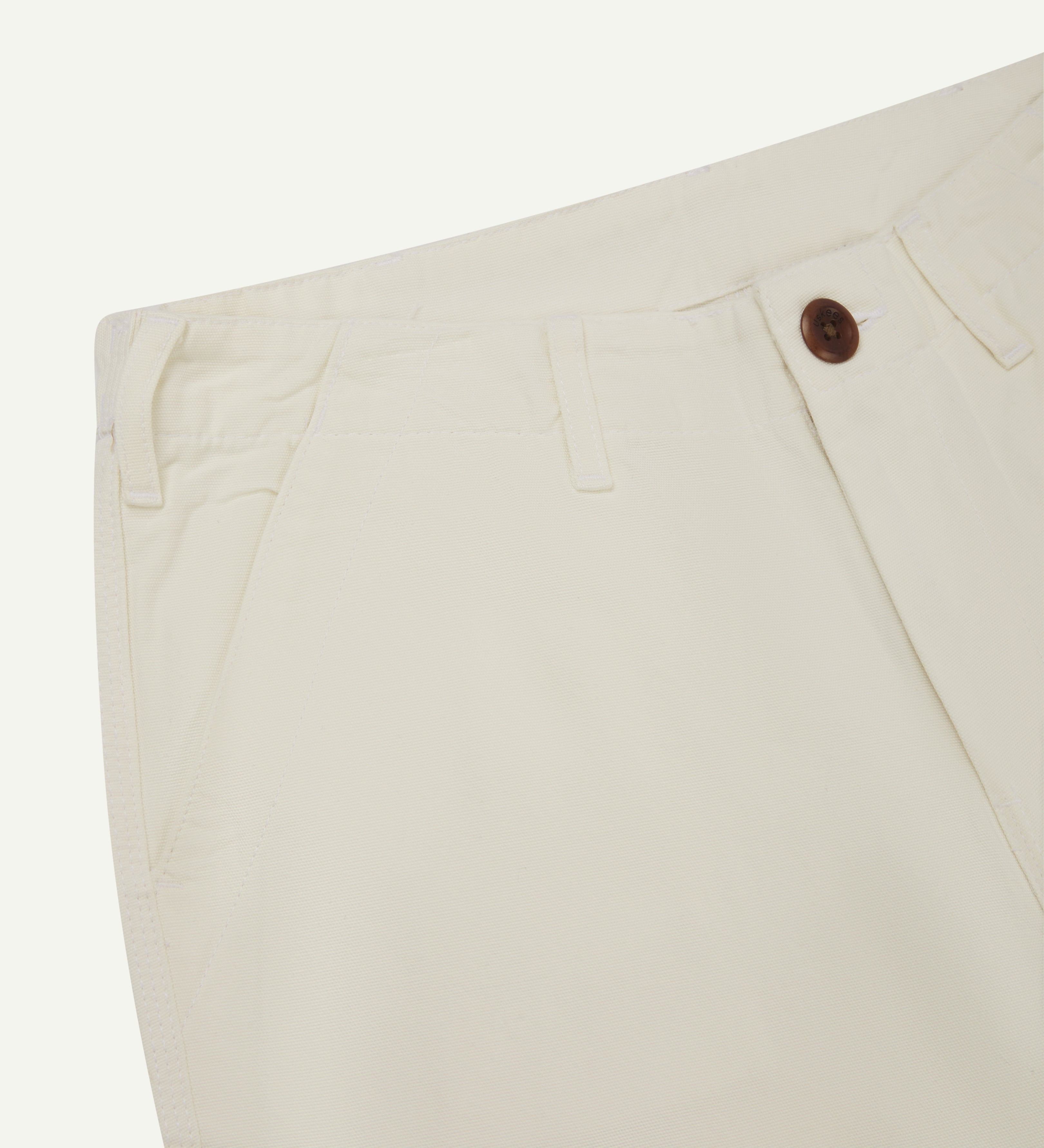Front close-up view of #5014 Uskees men's organic cotton cream cargo trousers showing contrast brown corozo buttons at waist