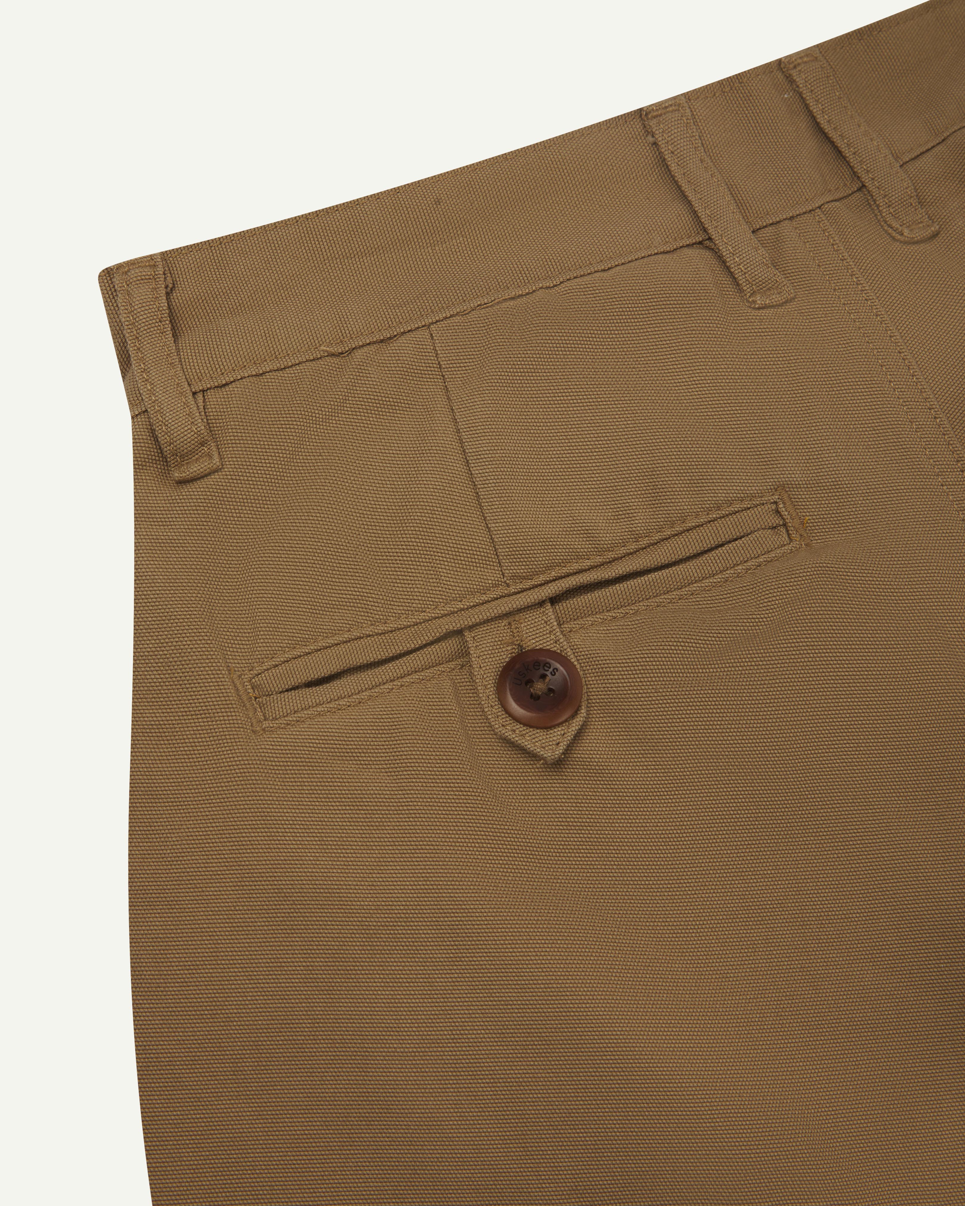 Back close up shot of #5018 Uskees men's organic mid-weight cotton boat trousers in khaki showing waistband with belt loops and buttoned back pocket.