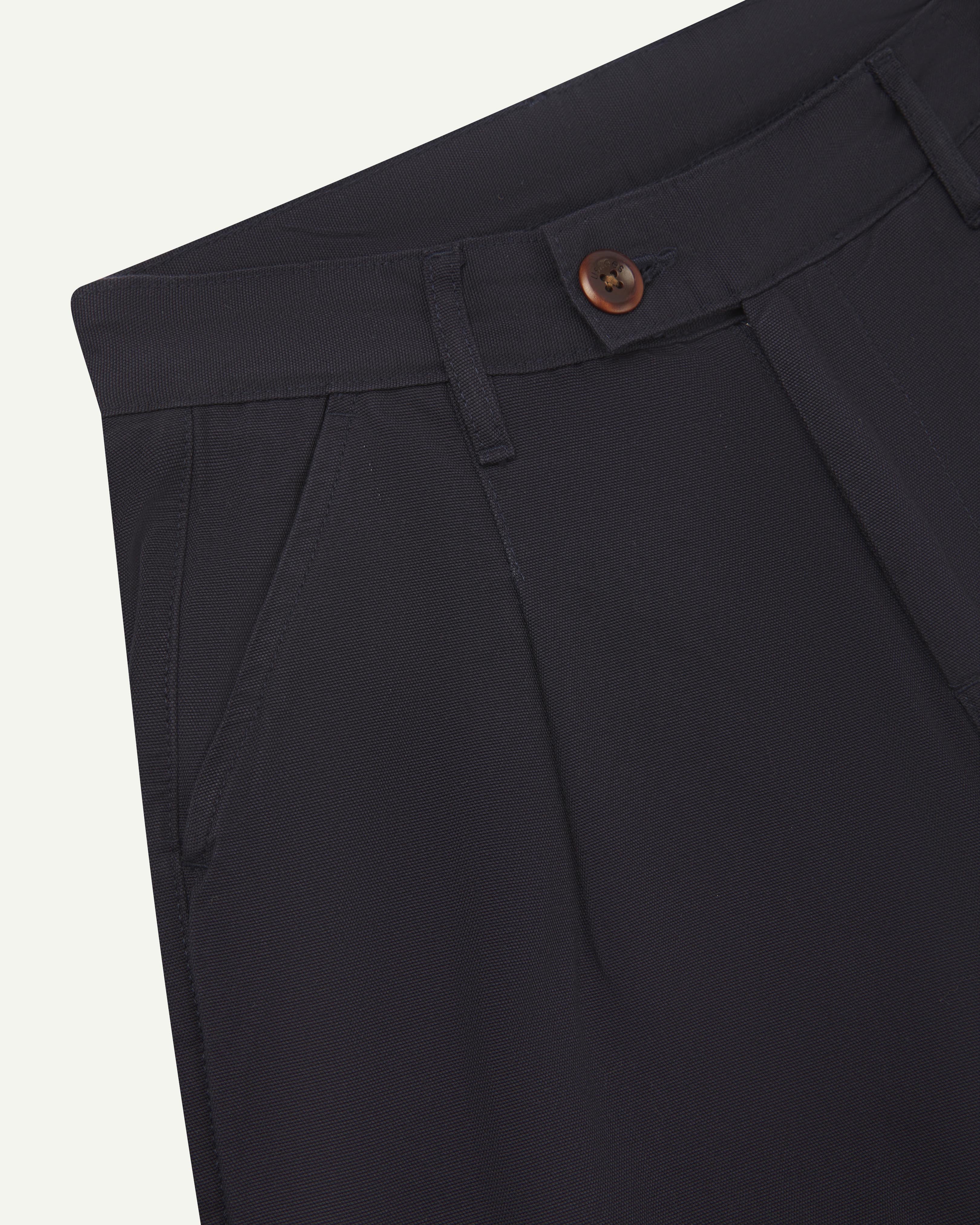 Front close-up shot of #5018 Uskees men's organic mid-weight cotton boat trousers in dark blue showing waist band fastening , belt loops and slanted front pocket