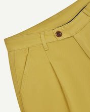 Front close-up shot of #5018 Uskees men's organic mid-weight cotton boat trousers in yellow showing corozo button fastening at waistband, belt loops and front pocket.