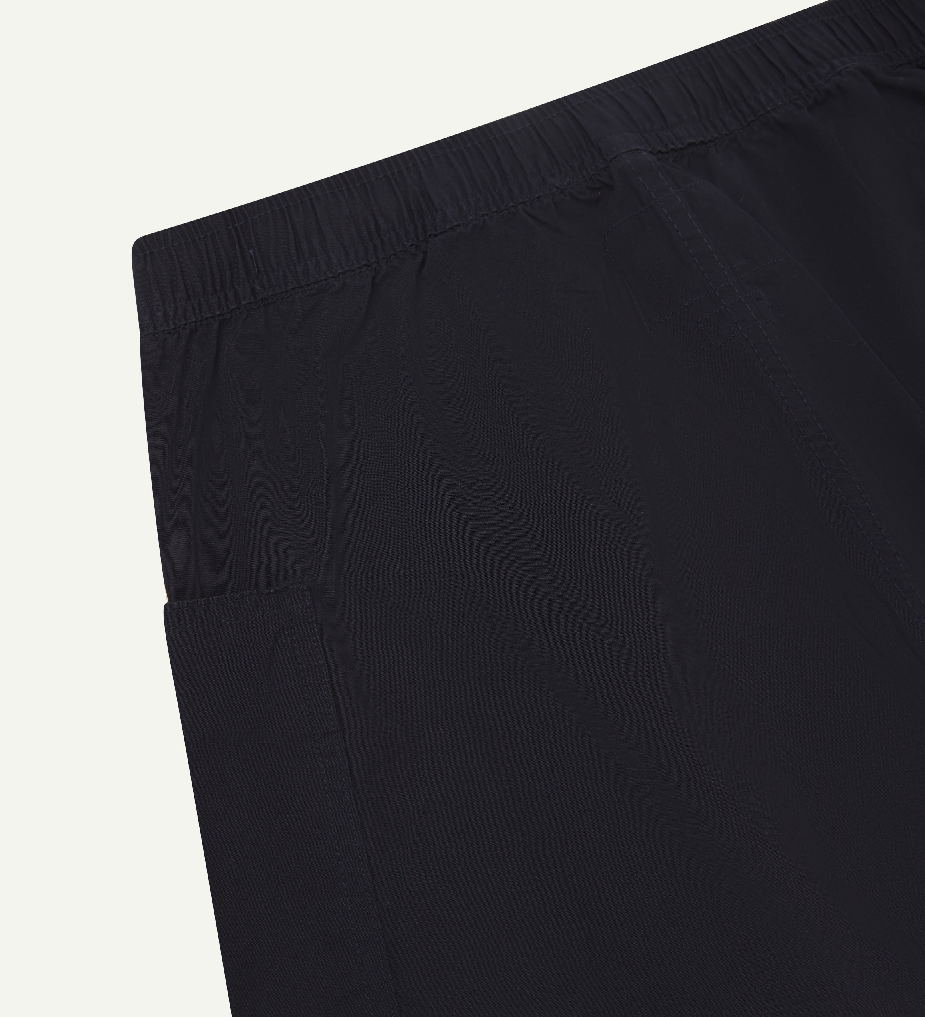Close-up of the back of the lightweight organic midnight-blue cotton pants showing the elasticated waist.