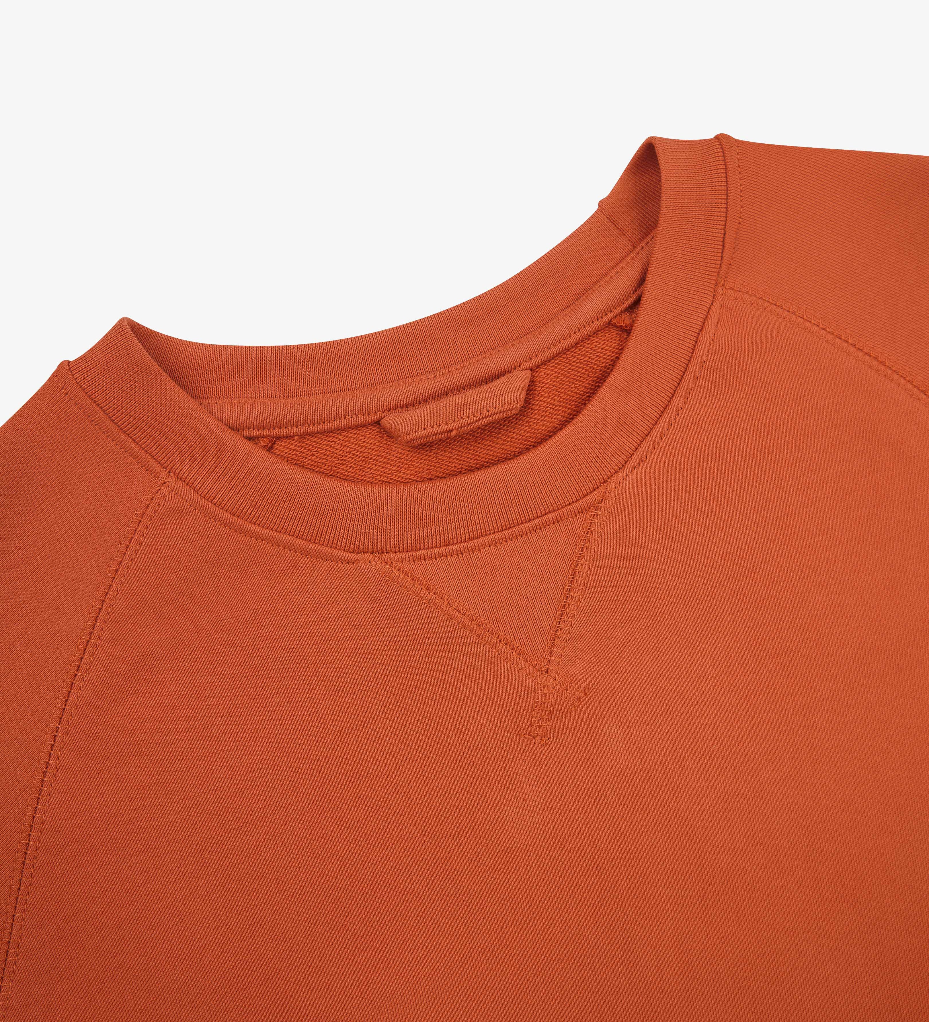 Close-up view of crew neck collar with decorative v-insert on Uskees cinnamon-red heavyweight cotton jersey sweatshirt.