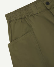 Close-up view of olive green organic cotton #5015 lightweight cotton shorts by Uskees showing elasticated waist and deep front pocket.