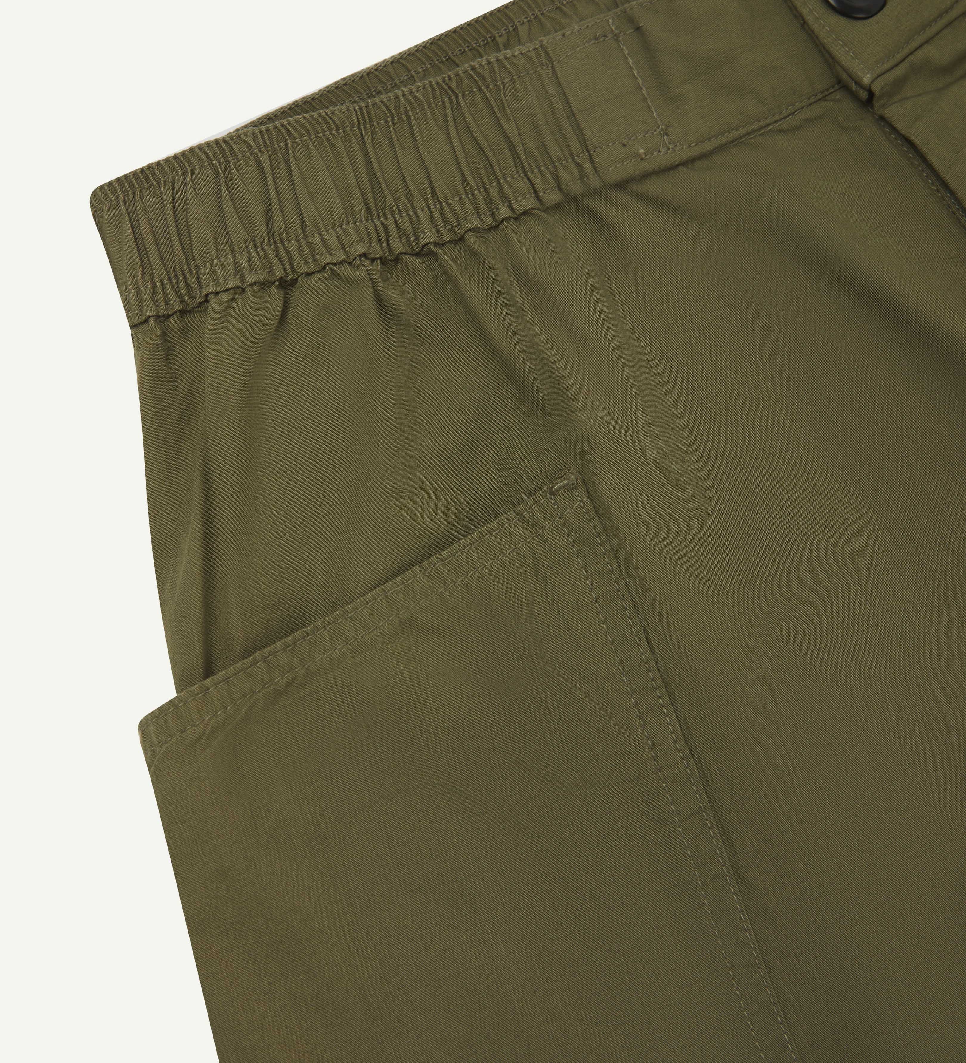 Close-up view of olive green organic cotton #5015 lightweight cotton shorts by Uskees showing elasticated waist and deep front pocket.