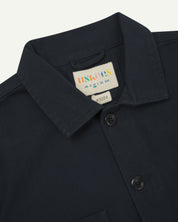 Front close view of uskees cotton drill overshirt with clear view of the collar, brand/size label  and brand label