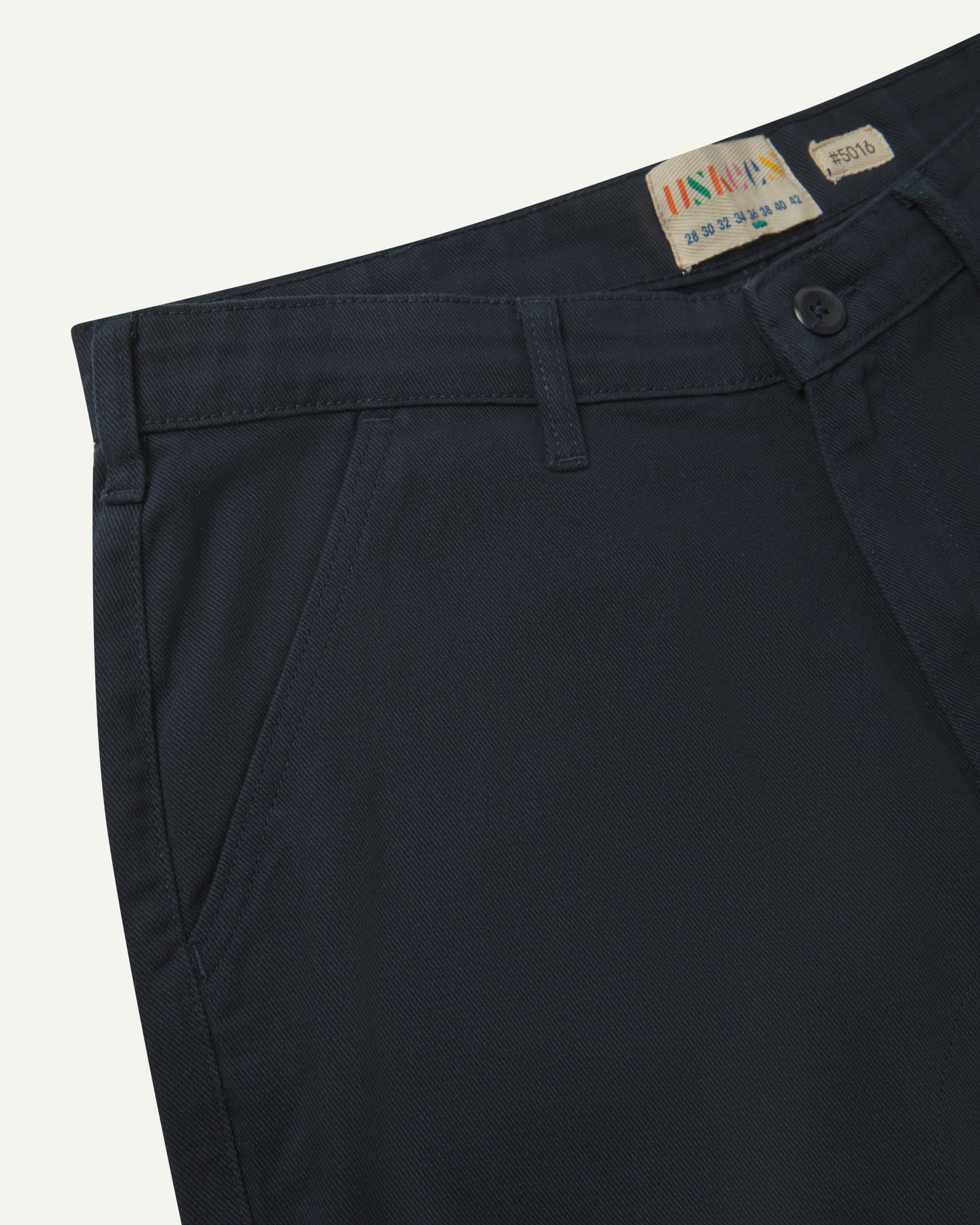 Front close view of uskees cotton drill 'commuter' trousers for men in dark blue showing belt loops, front pocket and brand/size label at waist.