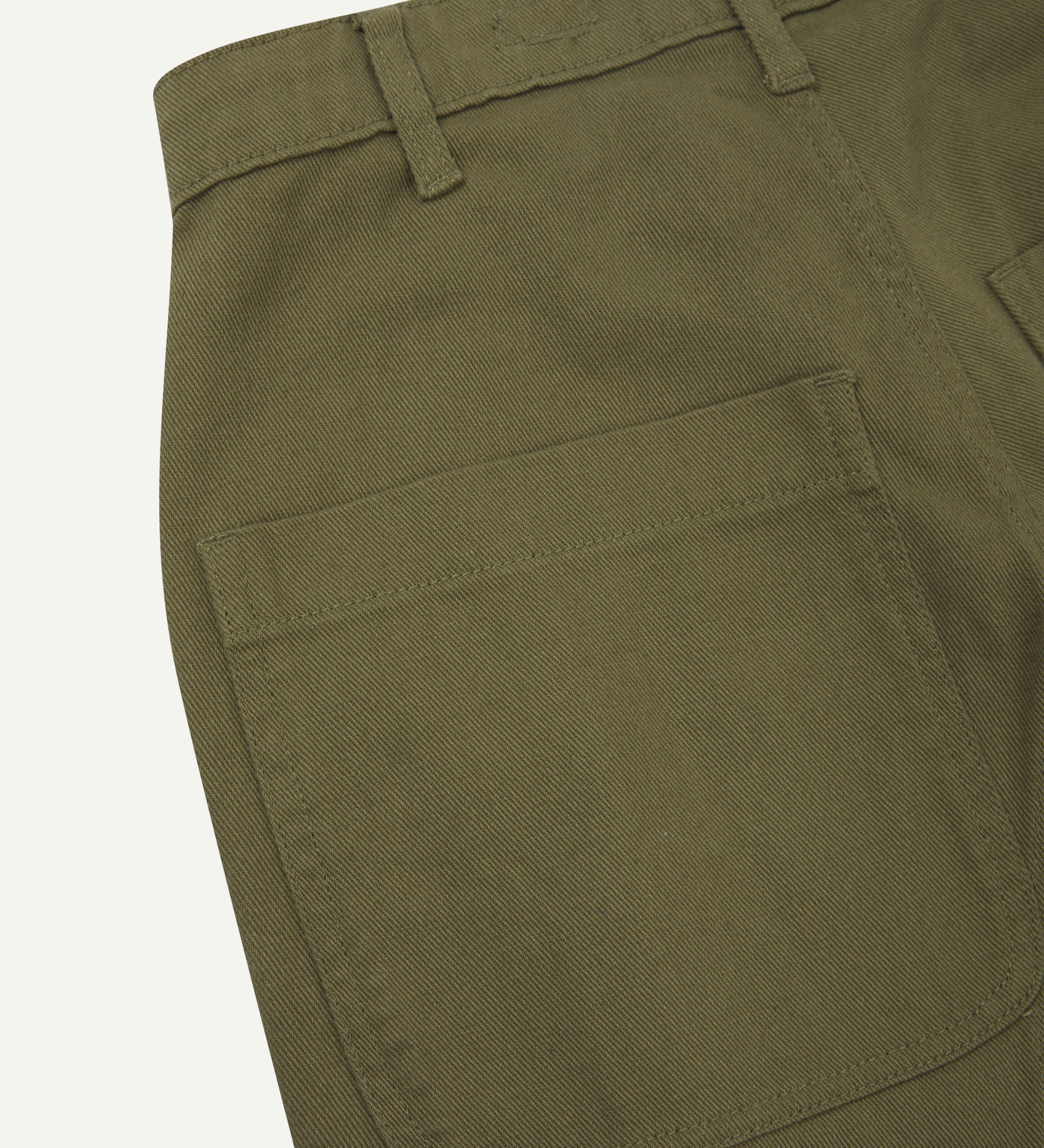 Back close-up view of uskees cotton drill 'commuter' trousers for men in moss green showing belt loops and back pocket.