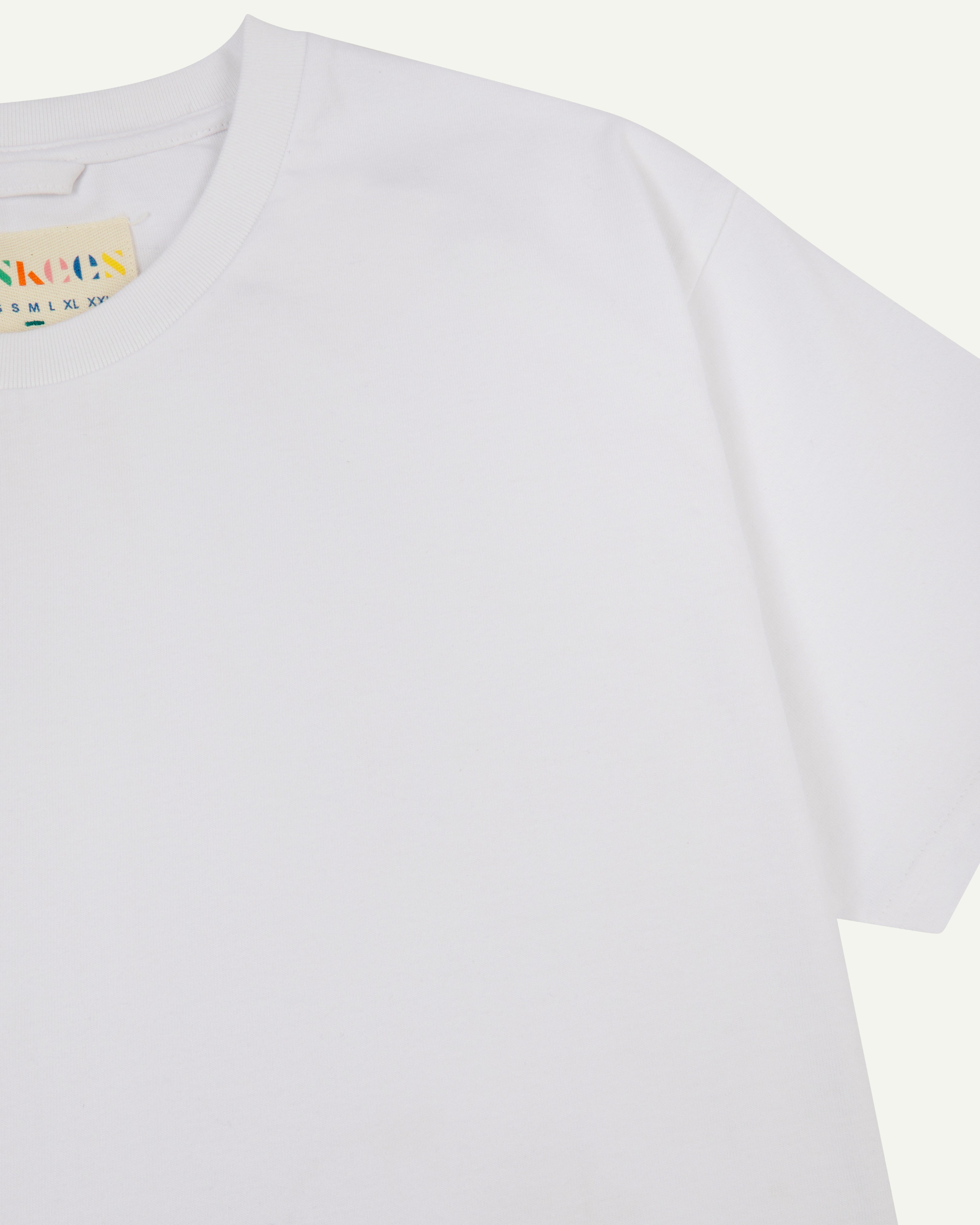 front view of uskees #7006 men's short sleeve T-shirt  in white showing part of uskees neck label.