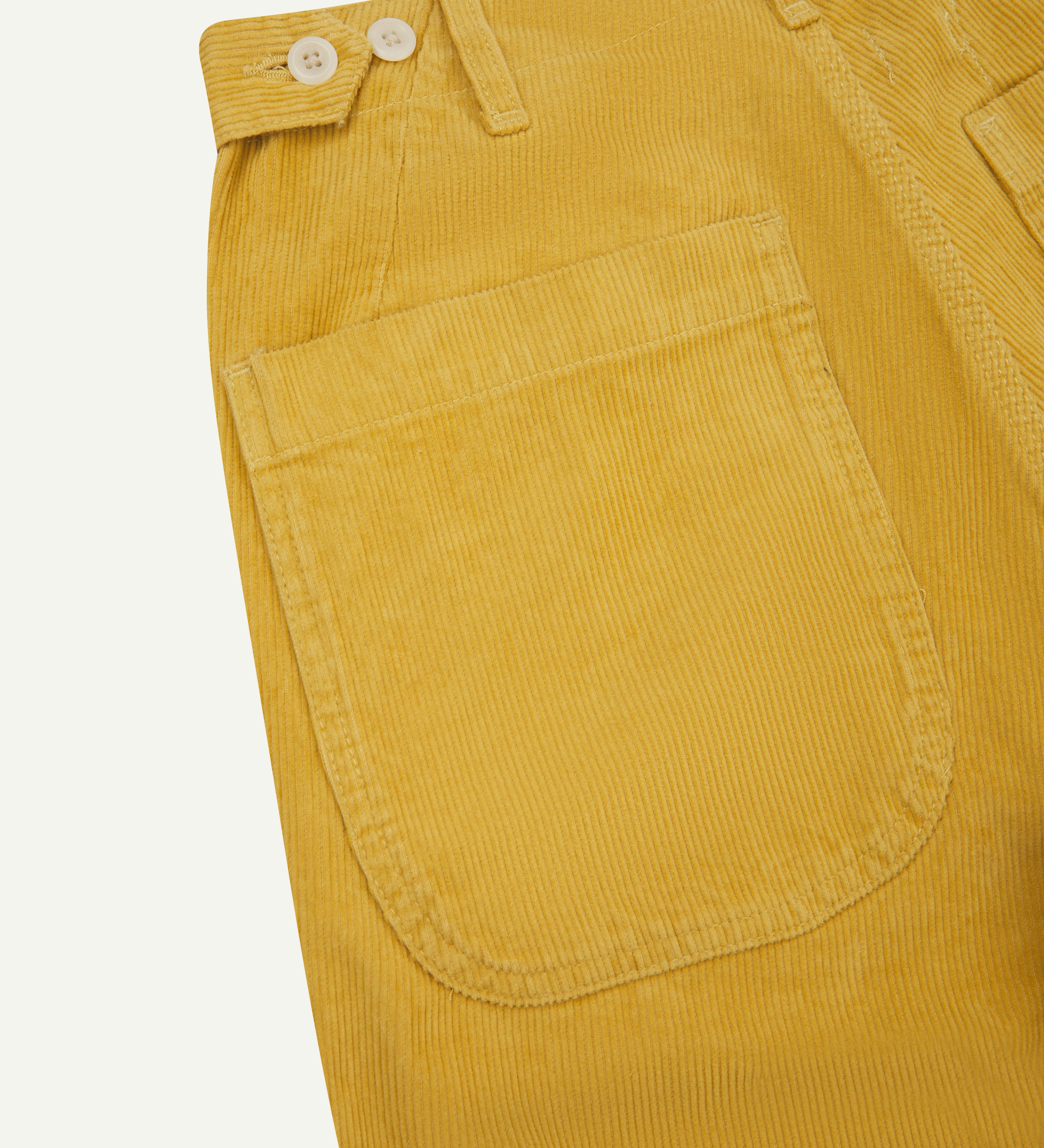 Close-up view of Uskees citronella-yellow work pants with focus on wide back pockets, tool pocket and organic 11 wale organic corduroy.