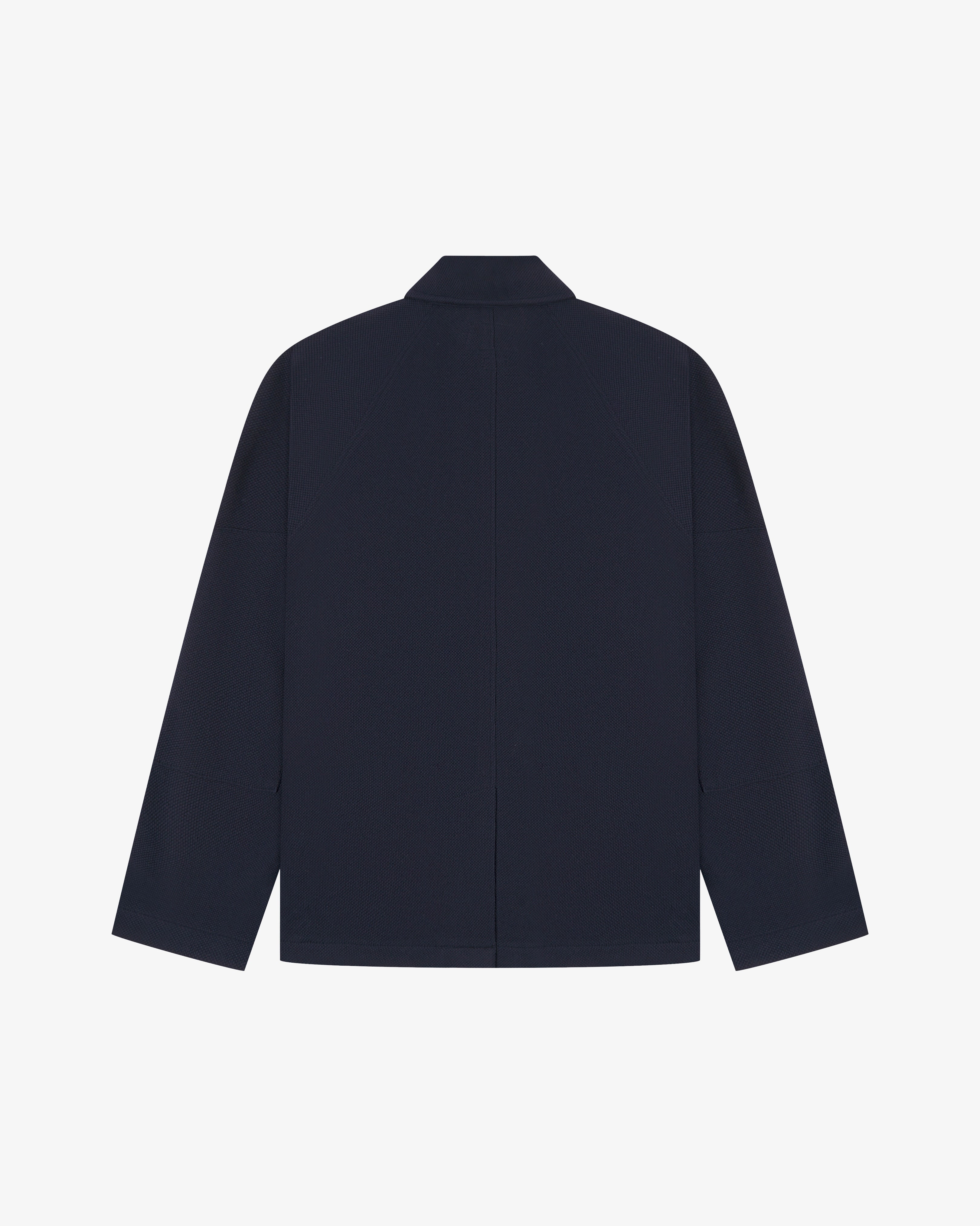 Flat back view of knitted organic cotton midnight blue blazer from Uskees with view of vent and reinforced elbows.