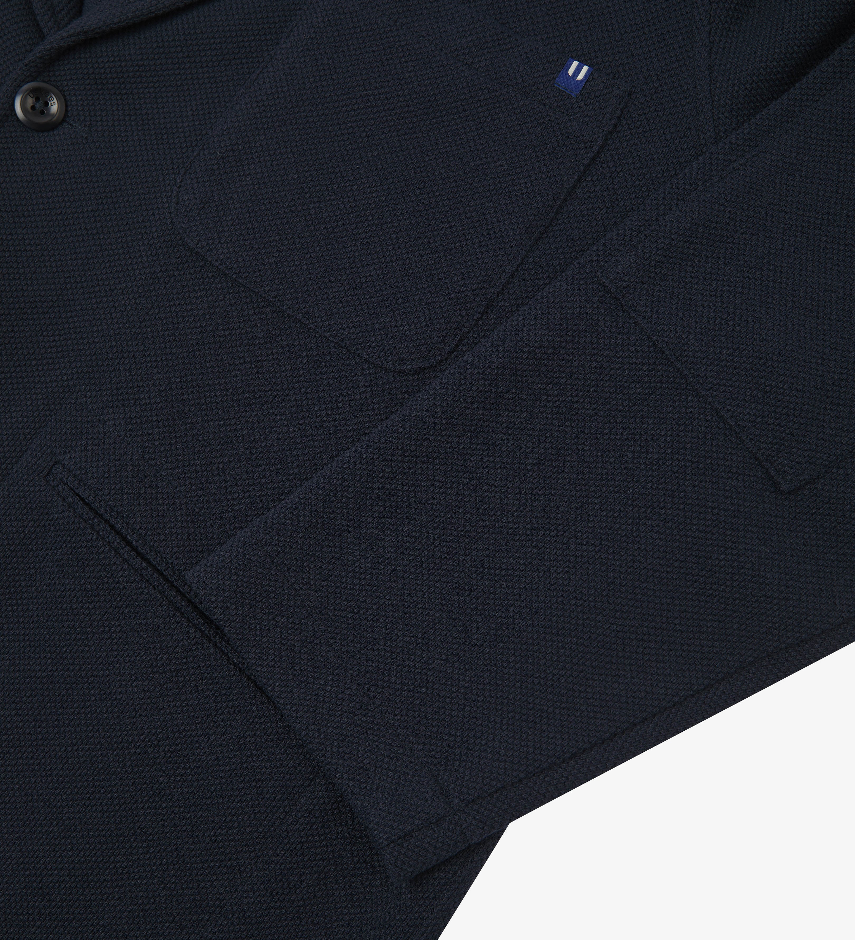 Close-up view of cuff and pockets of knitted organic cotton, midnight blue blazer from Uskees.