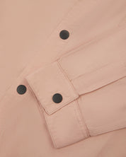 front flat shot of dusty pink uskees men's lightweight shirt with popper front and cuff fastening in close-up