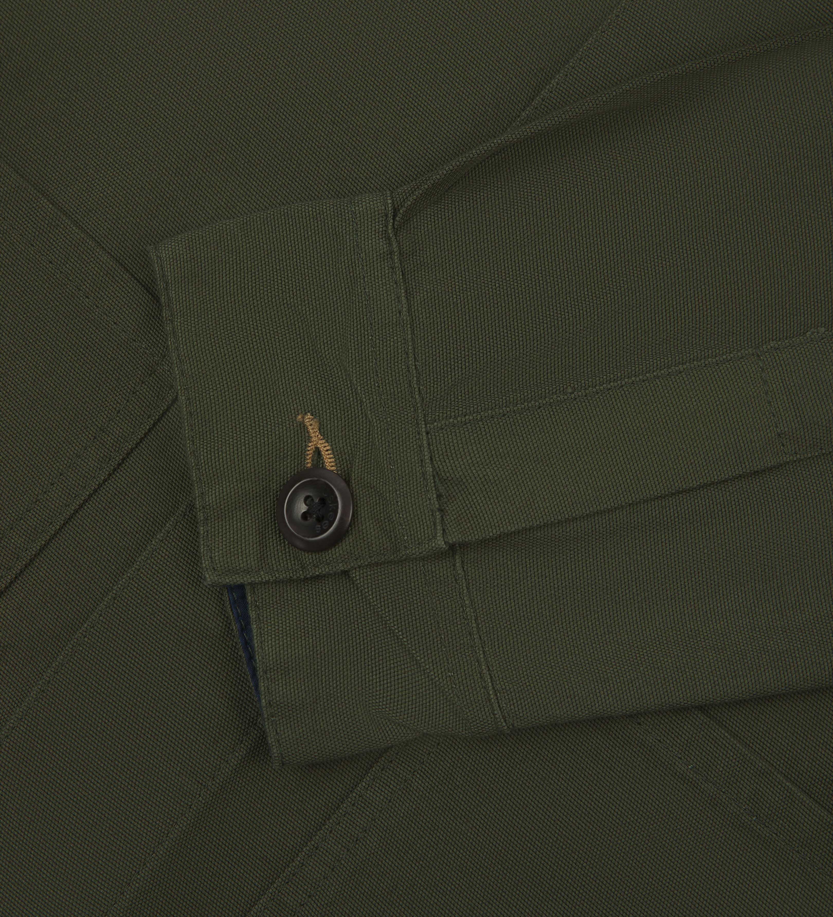 Front close up view of uskees men's dark green overshirt with hidden buttons showing buttoned cuff, sleeve and pockets.