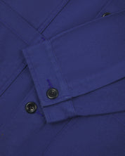 Close-up view of uskees cotton drill overshirt showing front pockets, corozo buttons and sleeve/cuff detail.