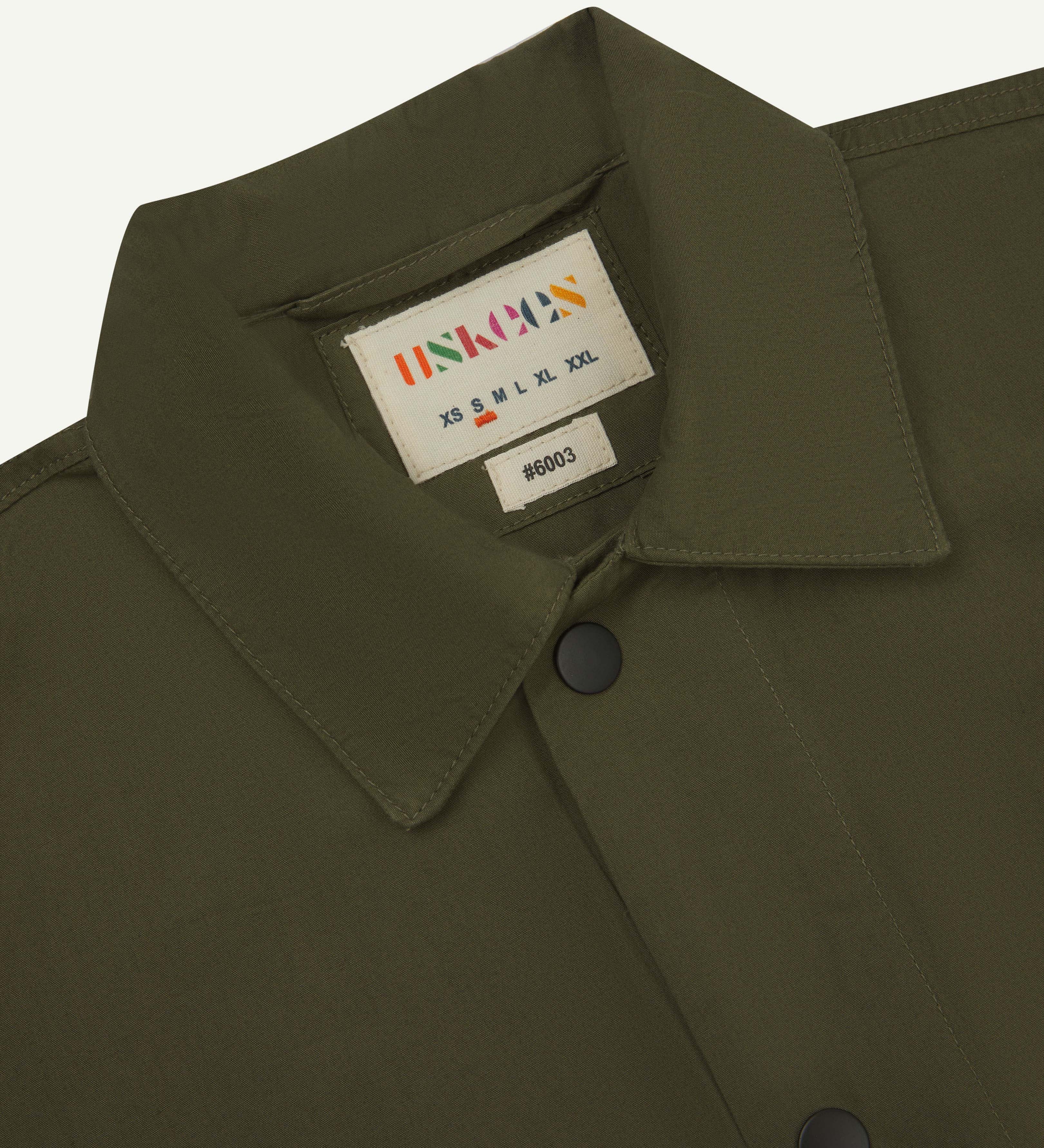 close up shot of uskees olive green men's #6003 shirt showing collar and black popper detail