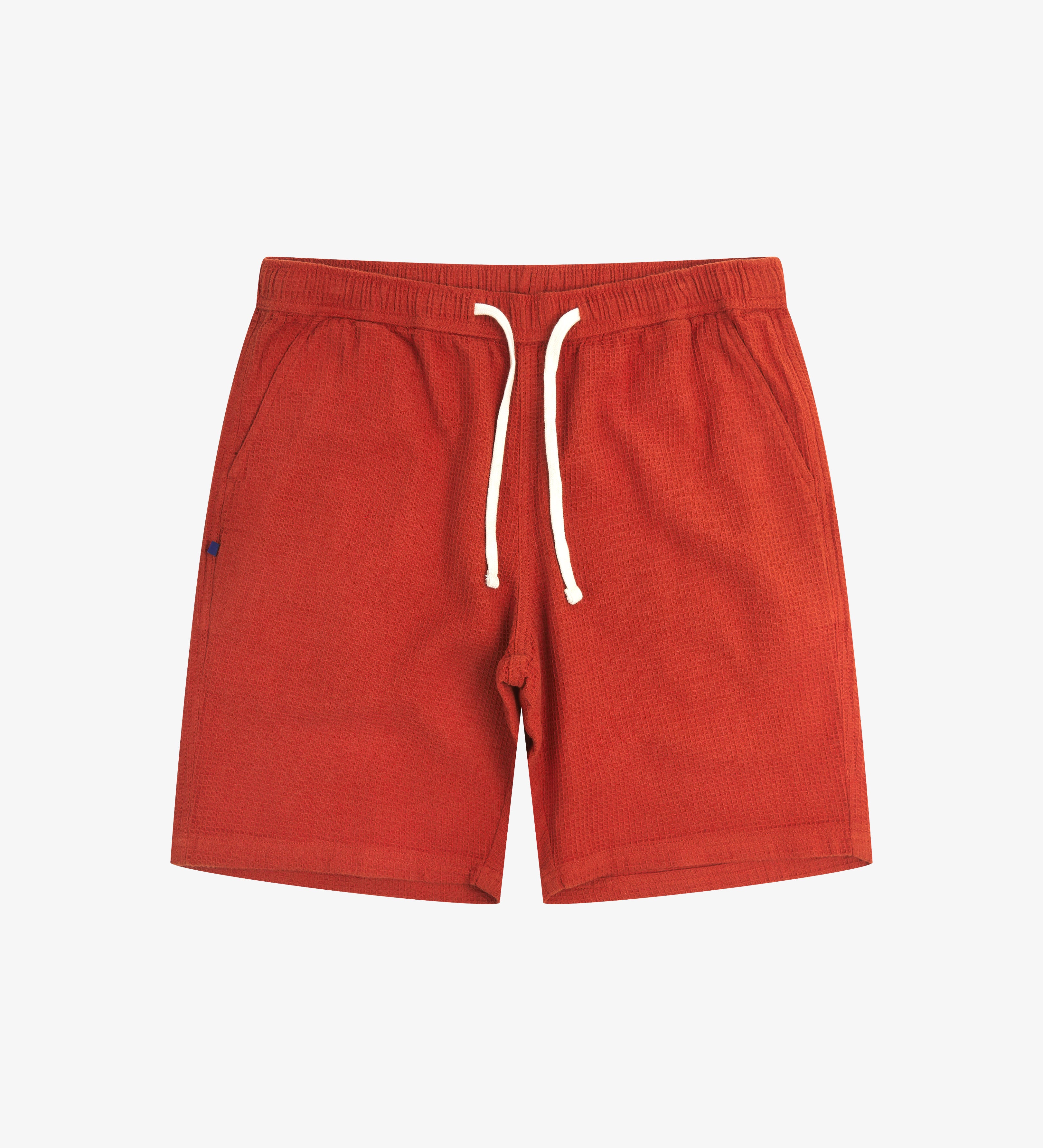 Front view of rust-red #6009 waffle cotton shorts. Clear view of white drawstring, side pockets and small Uskees tag label.