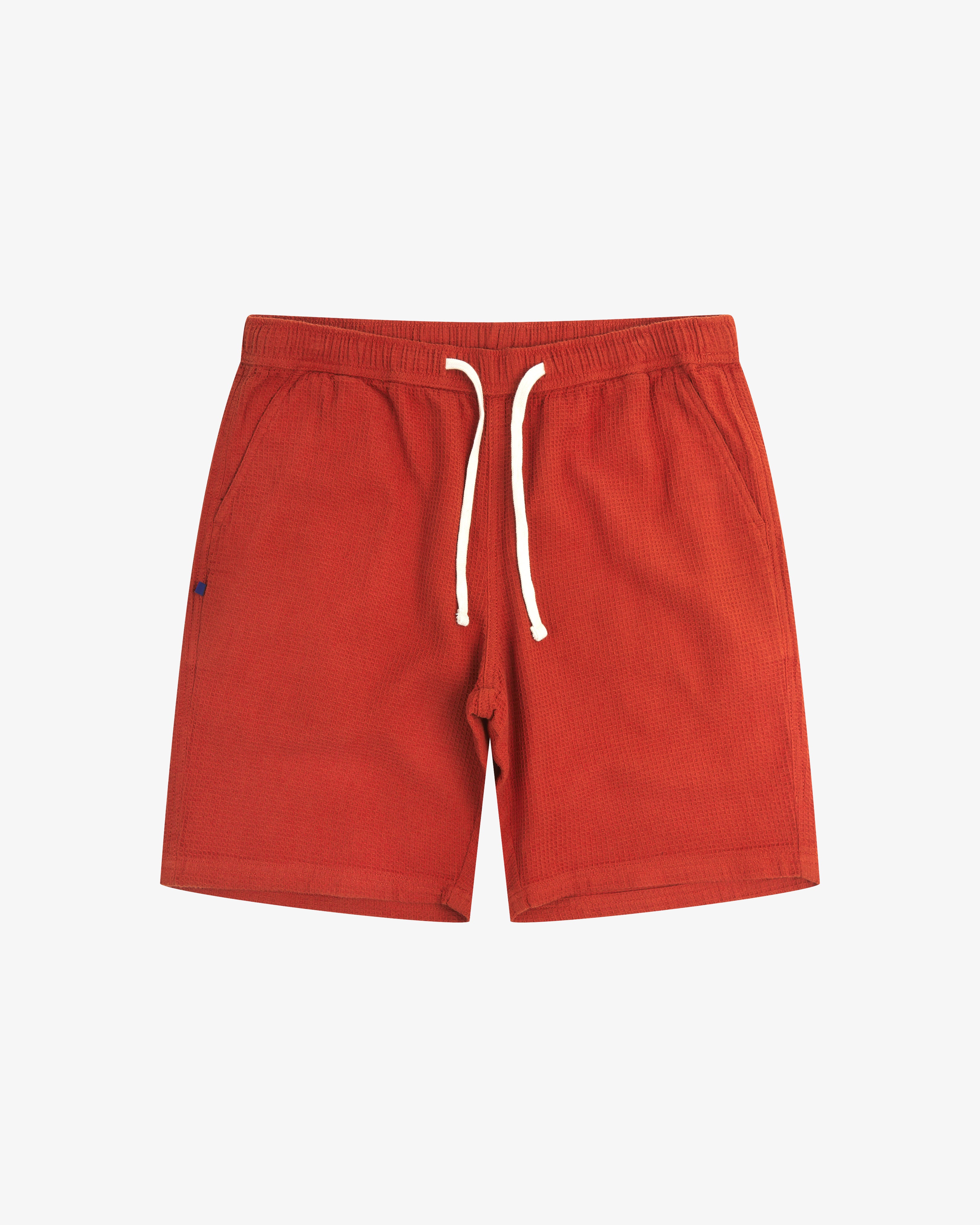 Front view of rust-red #6009 waffle cotton shorts. Clear view of white drawstring, side pockets and small Uskees tag label.