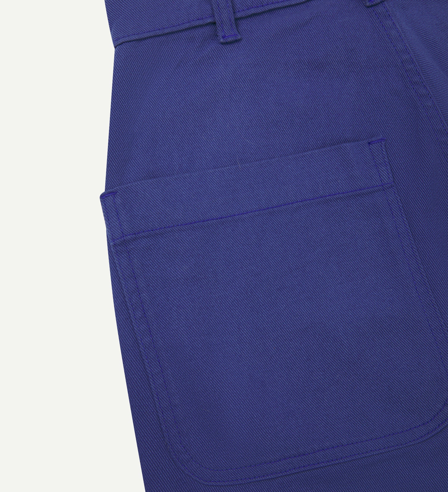Back close-up view of Uskees cotton drill 'commuter' trousers for men in ultra blue showing belt loops and back pocket.