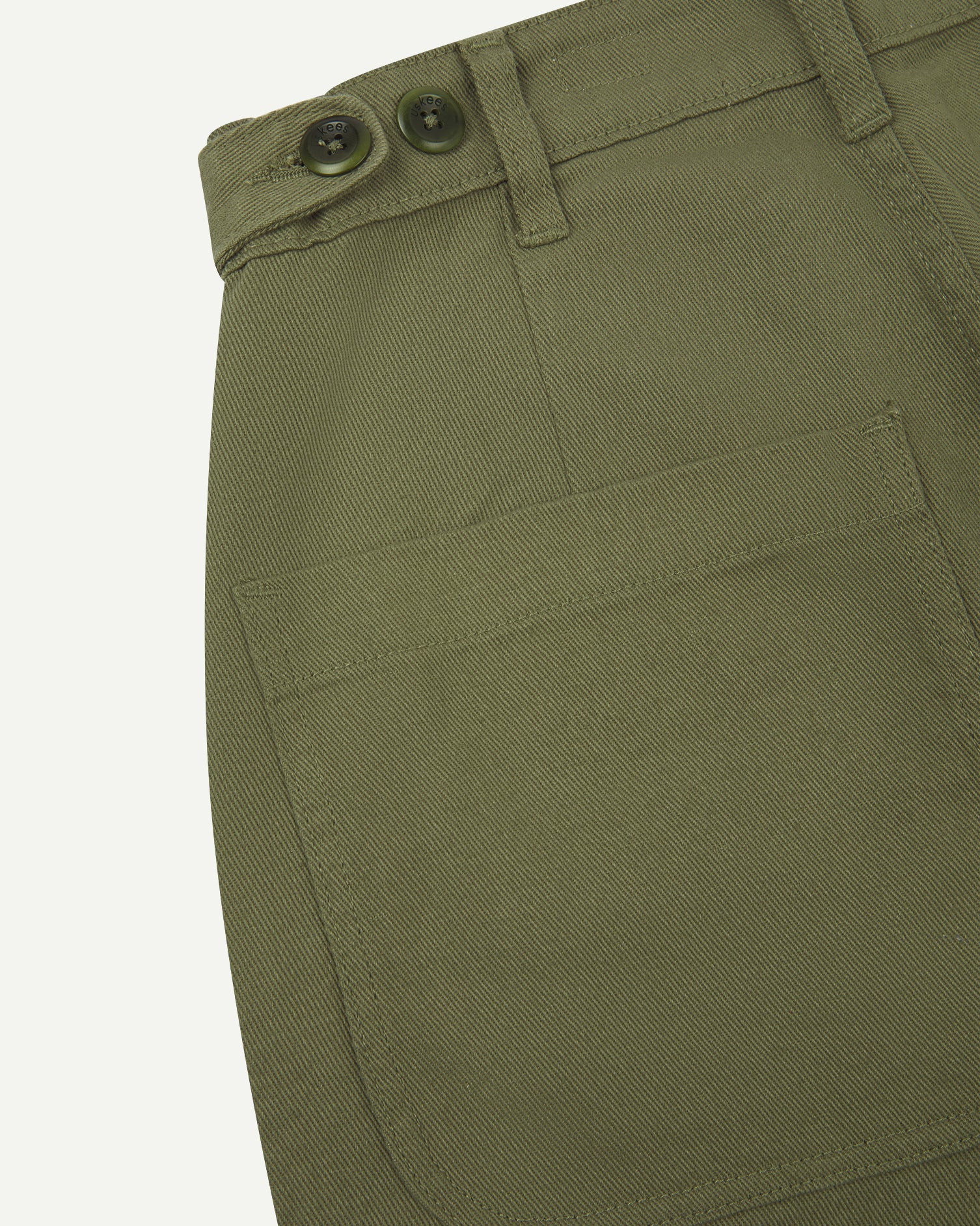 Close up shot of moss drill trousers from Uskees showing back pocket and waist band button adjusters