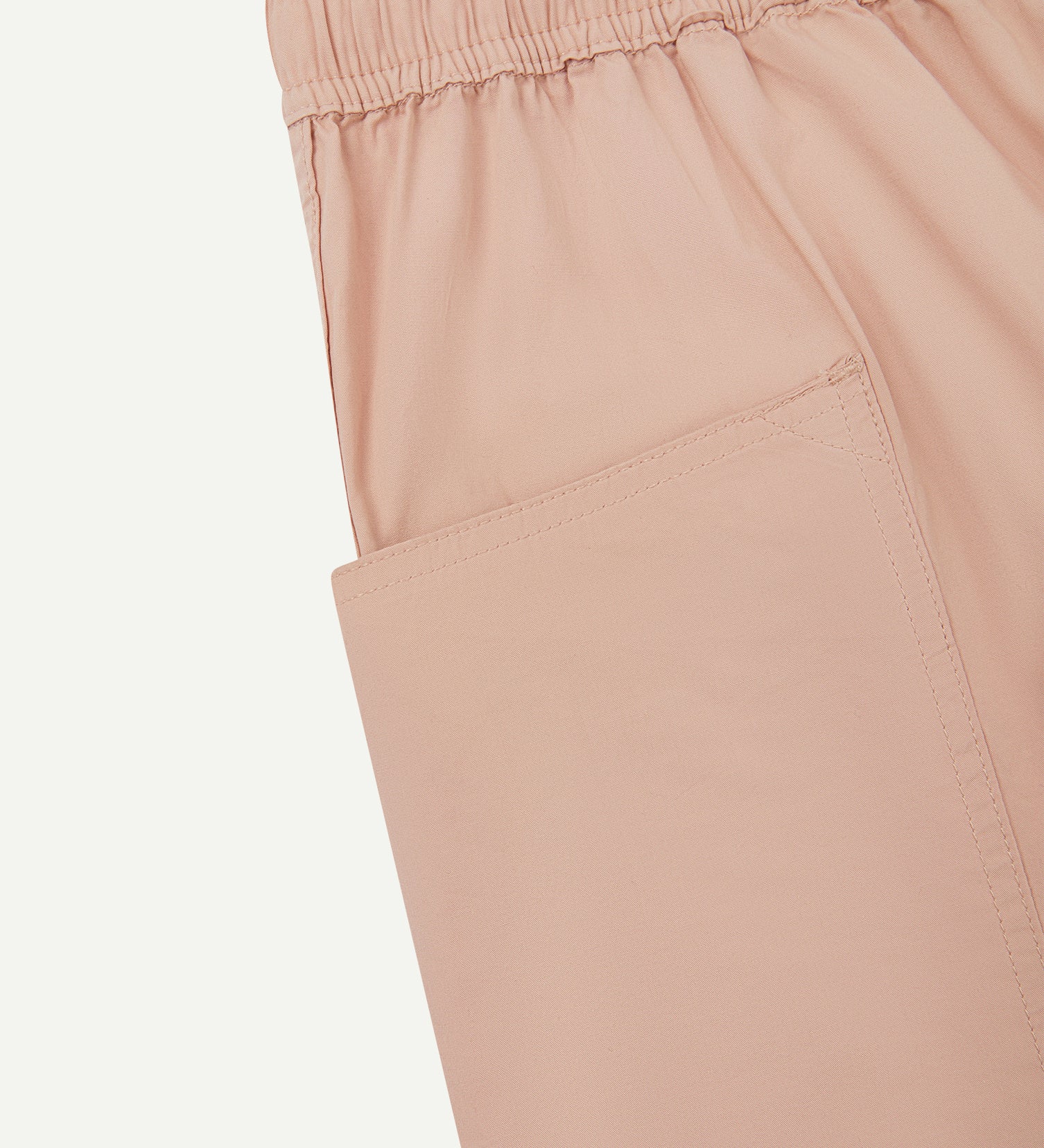 Close-up view of dusty pink organic cotton #5015 lightweight cotton shorts by Uskees showing elasticated waist and deep front pocket.