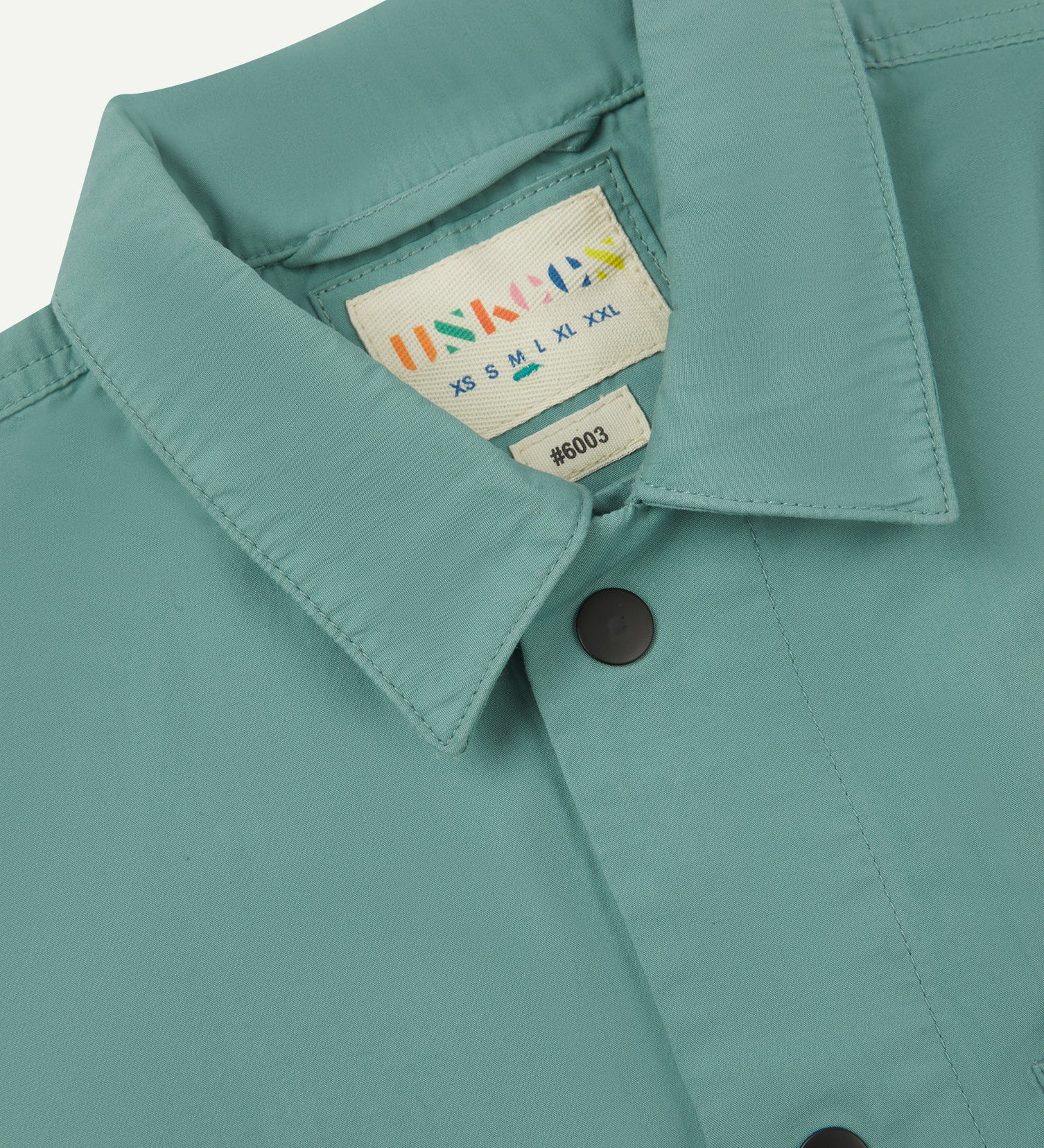 close up shot of Uskees eucalyptus men's #6003 shirt showing collar and black popper detail