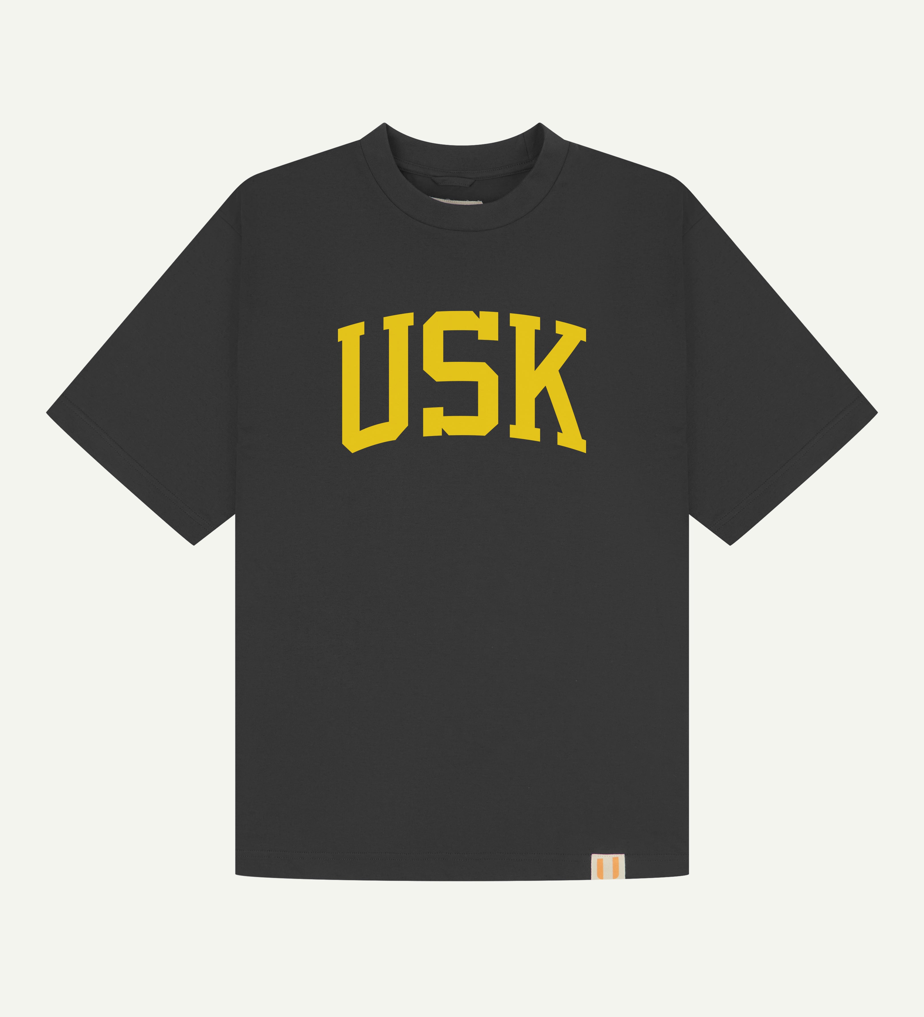 front flat shot of uskees signature oversized Tee in charcoal showing the yellow USK logo on the front.