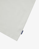 Close up shot of a men's white graphic t-shirt with 'USKEES' logo tab on the side seam. Presented on a white background