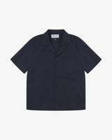 Front flat shot of an Uskees dark blue, button front, short sleeve shirt presented on a white background